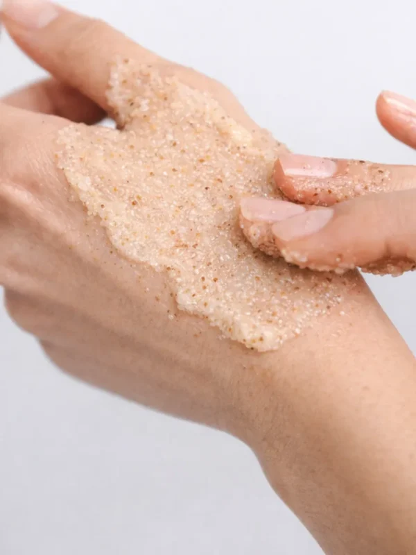 Application du gommage corps Sokoune sur la peau