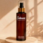 Huile sèche corps et cheveux Sokoune, flacon spray ambré 200 ml sur socle en travertin
